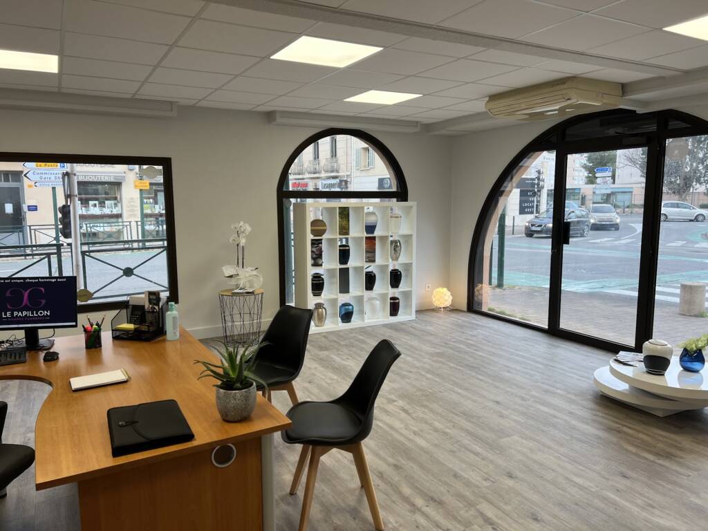 Intérieur de l'Agence La Garde Le Papillon avec espace d'accueil et exposition d'urnes funéraires.